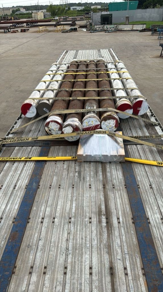 Banded OCTG pipe secured on a flatbed, top-down