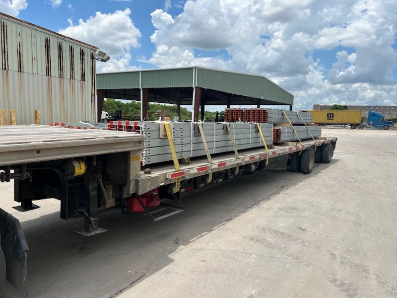 Galvanized steel beams loaded on a flatbed at a steel yard