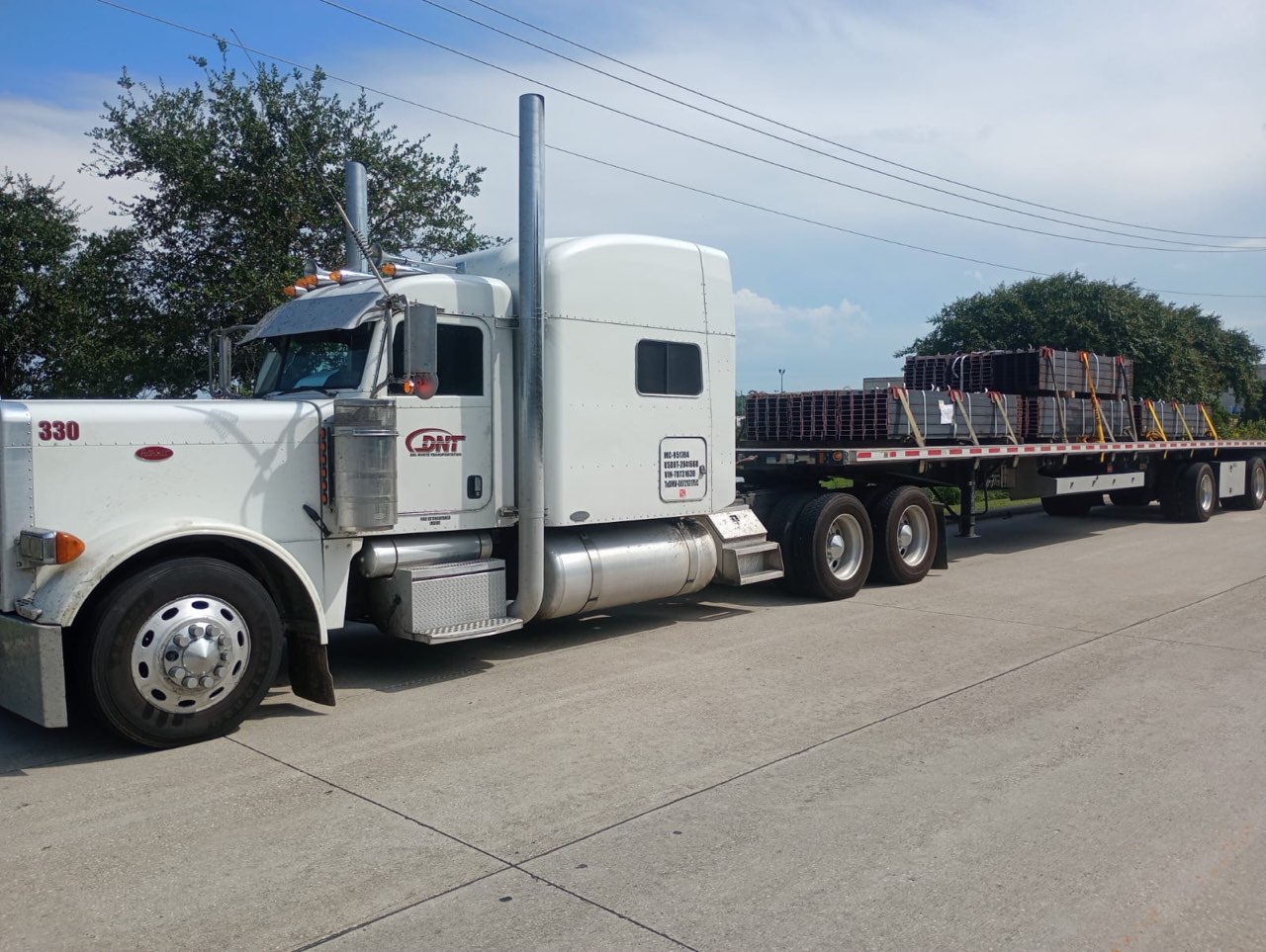 Flatbed truck staged at a freight facility ready for industrial load pickup