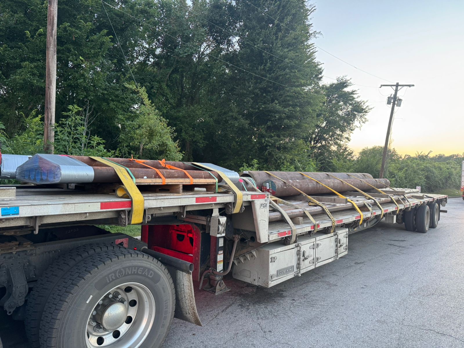 Secured pipe load on step deck at sunrise
